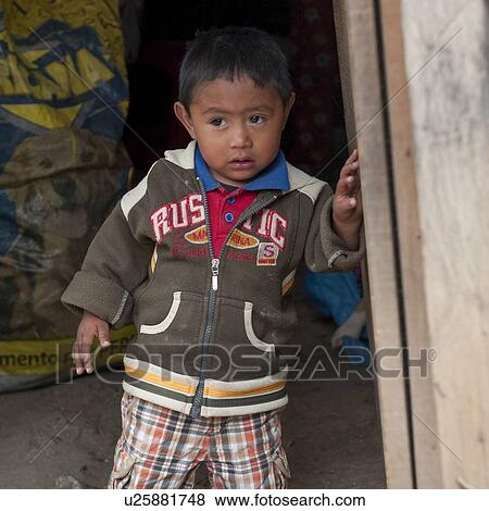 Stock Photo - Close-up of a boy standing at the doorway of a house, Zona 3, Guatemala City, Guatemala. Fotosearch