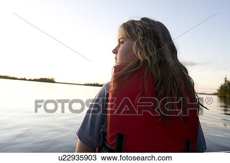 Stock Image - Close-up of a girl wearing life jacket, Lake of the Woods, Ontario, Canada. Fotosearch