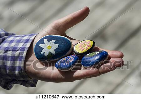 Close-up of a person's hand holding painted stones View Large Photo Image Stock Photo - Close-up of a person's hand holding painted stones. Fotosearch