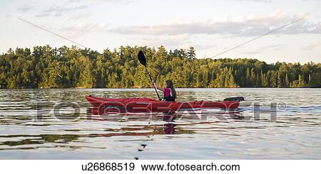 Girl kayaking in a lake, Lake of the Woods, Ontario, Canada View Large Photo Image Stock Photo - Girl kayaking in a lake, Lake of the Woods, Ontario, Canada. Fotosearch