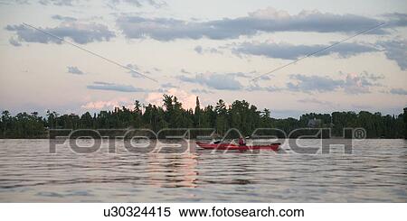 Stock Photography - Girl kayaking in a lake, Lake of the Woods, Ontario, Canada. Fotosearch