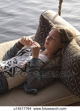 Girl resting on a swing, Lake of the Woods, Ontario, Canada View Large Photo Image Picture - Girl resting on a swing, Lake of the Woods, Ontario, Canada. Fotosearch