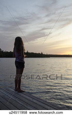 Stock Photo - Girl standing on a boardwalk, Lake of the Woods, Ontario, Canada. Fotosearch