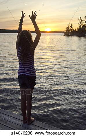 Girl standing on a boardwalk with her arms raised, Lake of the Woods, Ontario, Canada View Large Photo Image Stock Photo - Girl standing on a boardwalk with her arms raised, Lake of the Woods, Ontario, Canada. Fotosearch
