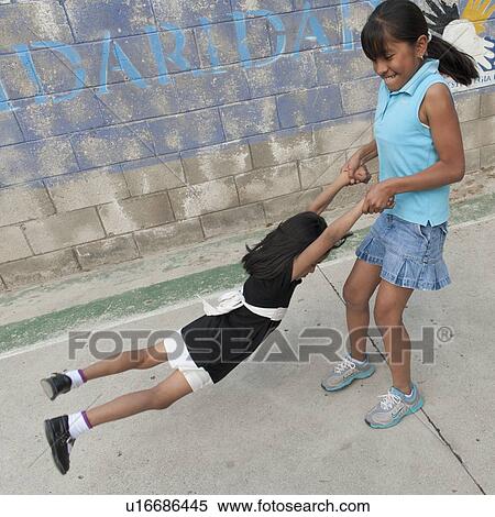 Girl swinging around her sister, Colonia Bethania, Guatemala City, Guatemala View Large Photo Image Stock Photography - Girl swinging around her sister, Colonia Bethania, Guatemala City, Guatemala. Fotosearch