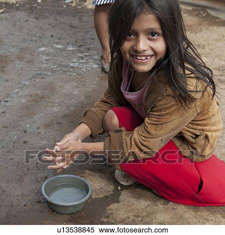 Stock Photography - Girl washing hands and smiling, Zona 3, Guatemala City, Guatemala. Fotosearch
