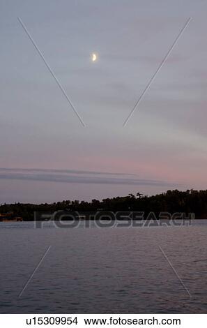 Picture - Half moon over the lake, Lake of the Woods, Ontario, Canada. Fotosearch
