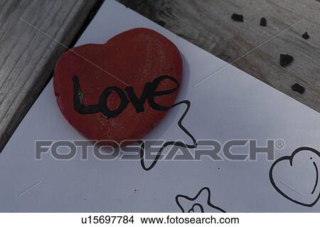 Picture - Heart shaped painted stone with word Love written on it, Lake of the Woods, Ontario, Canada. Fotosearch