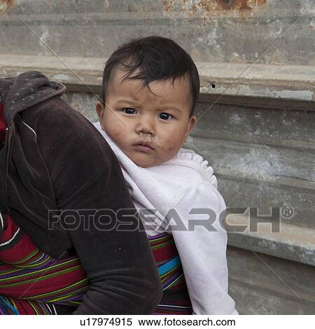 Stock Photography - Mother carrying her baby, Colonia Landivar, Guatemala City, Guatemala. Fotosearch