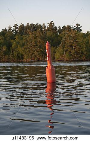 Stock Photograph - Navigational buoy in the middle of a lake, Lake of the Woods, Ontario, Canada. Fotosearch