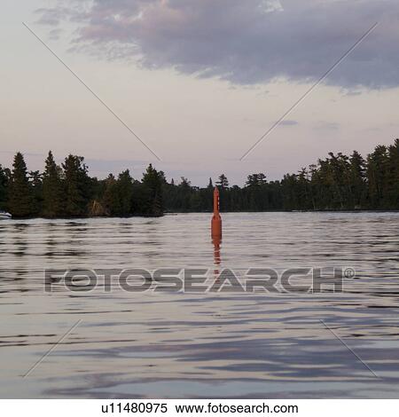 Stock Photography - Navigational buoy in the middle of a lake, Lake of the Woods, Ontario, Canada. Fotosearch