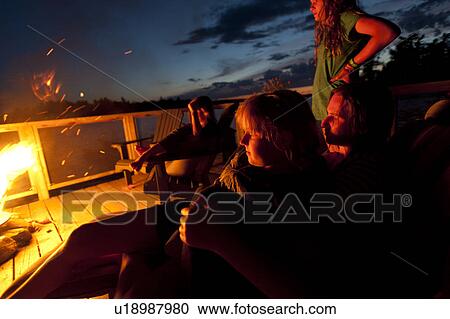 Stock Image - People near a campfire, Lake of the Woods, Ontario, Canada. Fotosearch