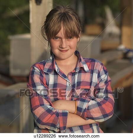 Stock Photograph - Portrait of a teenage girl standing with her arms crossed, Lake of the Woods, Ontario, Canada. Fotosearch
