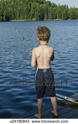 Stock Image - Rear view of a boy fishing in a lake, Lake of the Woods, Ontario, Canada. Fotosearch