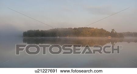 Stock Image - Reflection of trees in water, Lake of the Woods, Ontario, Canada. Fotosearch
