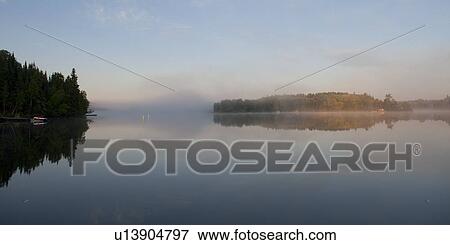 Stock Photo - Reflection of trees in water, Lake of the Woods, Ontario, Canada. Fotosearch