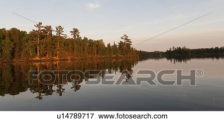 Reflection of trees in water, Lake of the Woods, Ontario, Canada View Large Photo Image Stock Photo - Reflection of trees in water, Lake of the Woods, Ontario, Canada. Fotosearch