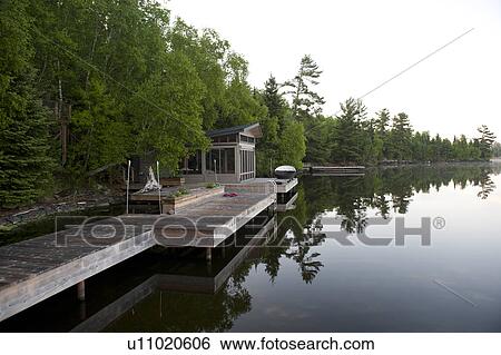 Stock Photograph - Reflection of trees in water, Lake of the Woods, Ontario, Canada. Fotosearch
