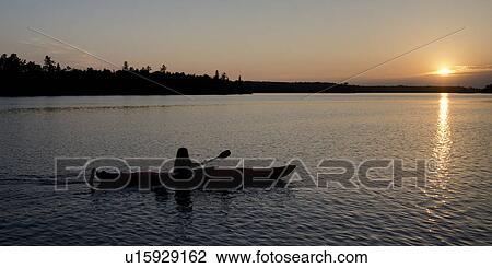 Silhouette of a person rowing a boat, Lake of the Woods, Ontario, Canada View Large Photo Image Stock Image - Silhouette of a person rowing a boat, Lake of the Woods, Ontario, Canada. Fotosearch