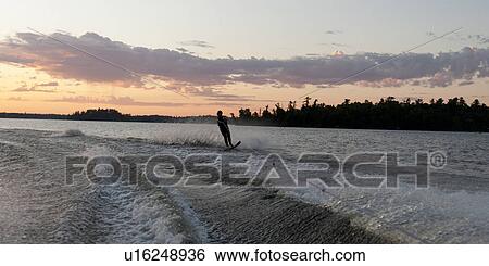 Silhouette of a person waterskiing in a lake, Lake of the Woods, Ontario, Canada View Large Photo Image Stock Photograph - Silhouette of a person waterskiing in a lake, Lake of the Woods, Ontario, Canada. Fotosearch
