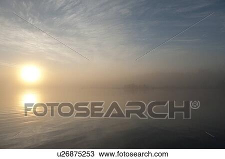 Stock Image - Sunrise over the lake, Lake of the Woods, Ontario, Canada. Fotosearch