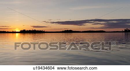 Picture - Sunset over a lake, Lake of the Woods, Ontario, Canada. Fotosearch