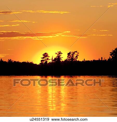 Stock Photo - Sunset over a lake, Lake of the Woods, Ontario, Canada. Fotosearch