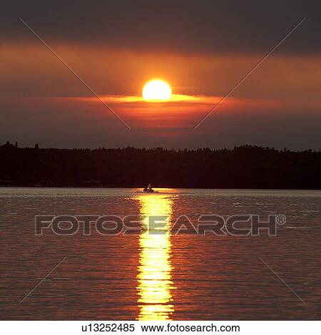 Stock Photography - Sunset over a lake, Lake of the Woods, Ontario, Canada. Fotosearch