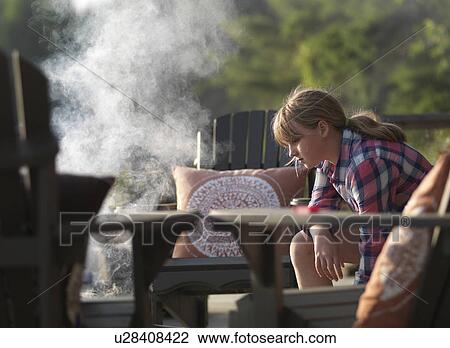 Stock Image - Teenage girl roasting marshmallow, Lake of the Woods, Ontario, Canada. Fotosearch