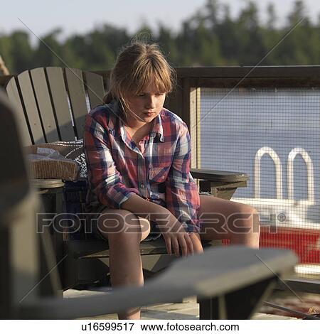 Stock Photo - Teenage girl roasting marshmallow, Lake of the Woods, Ontario, Canada. Fotosearch