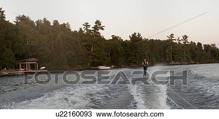 Stock Image - Tourist waterskiing in a lake, Lake of the Woods, Ontario, Canada. Fotosearch