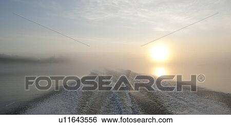 Wake in a fog covered lake during sunset, Lake of the Woods, Ontario, Canada View Large Photo Image Stock Photograph - Wake in a fog covered lake during sunset, Lake of the Woods, Ontario, Canada. Fotosearch