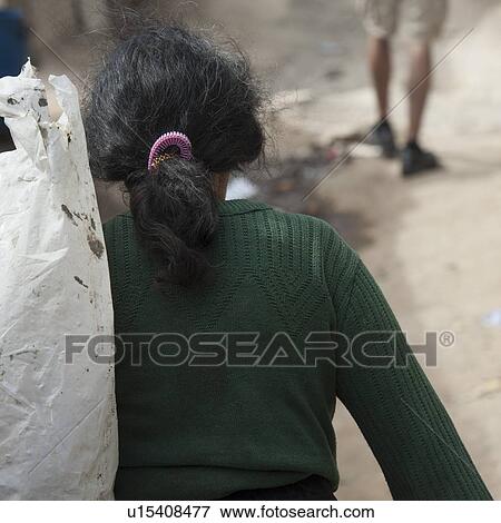 Stock Photo - Woman carrying a garbage bag, Zona 3, Guatemala City, Guatemala. Fotosearch