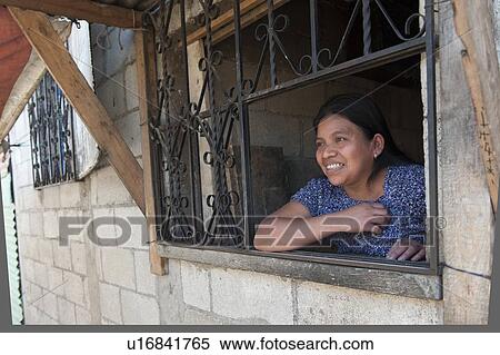 Woman looking through a window and smiling, Colonia Landivar, Guatemala City, Guatemala View Large Photo Image Stock Photography - Woman looking through a window and smiling, Colonia Landivar, Guatemala City, Guatemala. Fotosearch