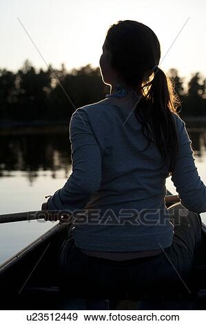 Woman rowing a boat in a lake, Lake of the Woods, Ontario, Canada View Large Photo Image Stock Photo - Woman rowing a boat in a lake, Lake of the Woods, Ontario, Canada. Fotosearch