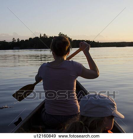 Stock Photo - Woman rowing a boat with her daughter, Lake of the Woods, Ontario, Canada. Fotosearch