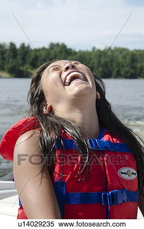 Woman wearing a life jacket and laughing, Lake of the Woods, Ontario, Canada View Large Photo Image Stock Photography - Woman wearing a life jacket and laughing, Lake of the Woods, Ontario, Canada. Fotosearch