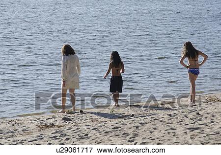 Stock Photo - Woman with her two daughters walking on the beach, Lake of the Woods, Ontario, Canada. Fotosearch
