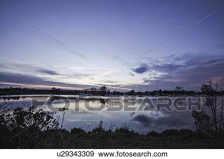 Stock Photo - Blue sky reflected in still rural river. Fotosearch
