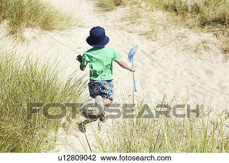 Boy carrying fishing net on beach View Large Photo Image Stock Image - Boy carrying fishing net on beach. Fotosearch