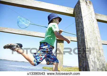 Boy carrying fishing net on dock View Large Photo Image Stock Image - Boy carrying fishing net on dock. Fotosearch