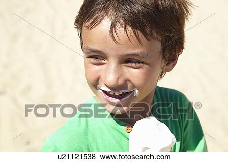 Boy eating ice cream on beach View Large Photo Image Stock Photo - Boy eating ice cream on beach. Fotosearch