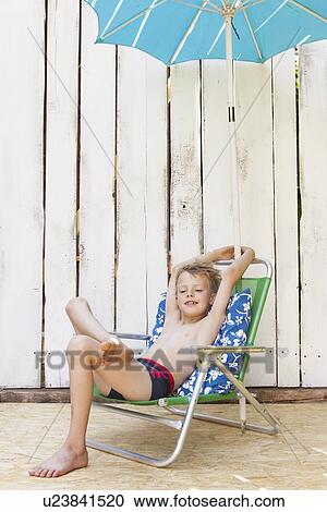 Boy in swimsuit in lawn chair indoors View Large Photo Image Stock Image - Boy in swimsuit in lawn chair indoors. Fotosearch