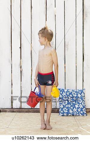 Boy in swimsuit with beach toys indoors View Large Photo Image Stock Image - Boy in swimsuit with beach toys indoors. Fotosearch