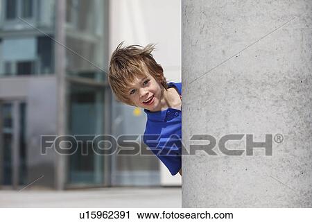 Boy peering out from behind column View Large Photo Image Stock Image - Boy peering out from behind column. Fotosearch