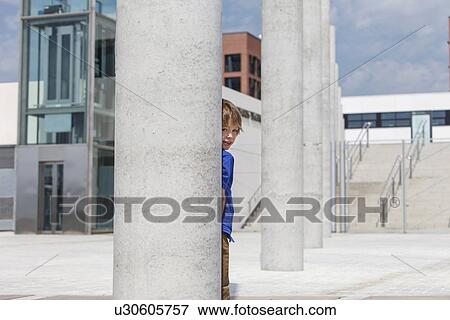Boy peering out from behind column View Large Photo Image Stock Photo - Boy peering out from behind column. Fotosearch