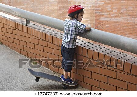 Boy peering over balcony outdoors View Large Photo Image Stock Photo - Boy peering over balcony outdoors. Fotosearch