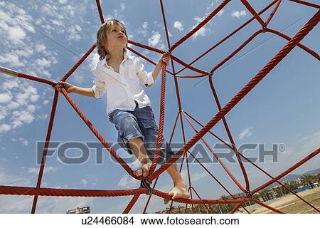 Picture - Boy playing on ropes on beach. Fotosearch