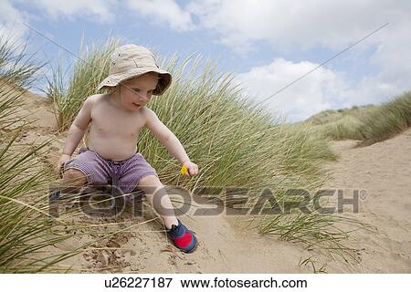 Boy playing on sand dune View Large Photo Image Stock Photo - Boy playing on sand dune. Fotosearch