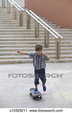Stock Image - Boy playing with skateboard outdoors. Fotosearch